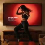 Een woonkamer met een dansende vrouw op een flatscreen tv